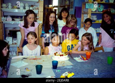 Elf Jahre altes chinesisches Mädchen Ausblasen der Kerzen auf Kuchen auf Geburtstagsparty Stockfoto