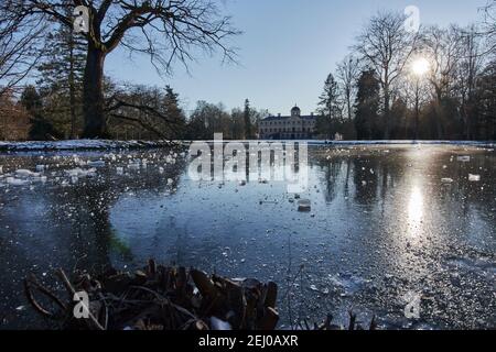 Gefrorener See am Lieblingspalastgarten mit Sonnenschein und blauem Himmel in Foerch, Rastatt, Deutschland Stockfoto