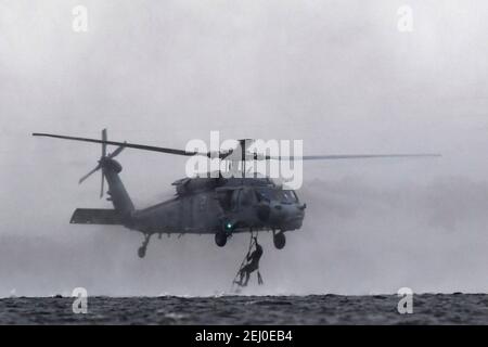 US Air Force Special Tactics Teams, die dem 24th Special Operations Wing zugewiesen sind, führen während des Emerald Warrior auf dem Hurlburt Field am 18. Februar 2021 in Mary Esther, Florida, Hubarbeitsoperationen mit einem Marine MH-60 Seahawk Hubschrauber durch. Stockfoto