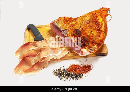 Schinken ohne Knochen, mit rotem Pfeffer und schwarzem Pfeffer, in Scheiben geschnitten. Auf weißem Hintergrund. Stockfoto
