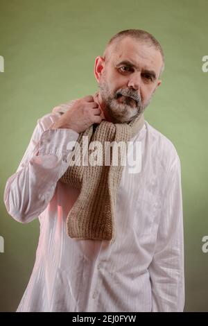 Ein hart arbeitender älterer Mann in einem kräftigen Zustand trotz einer Halsschmerzen in einen Schal gewickelt Stockfoto