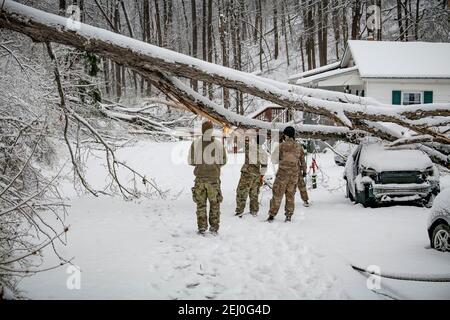 Ceredo, Usa. Februar 2021, 19th. US-Soldaten mit der Nationalgarde von West Virginia befreien Trümmer von einem Wintersturm von einer Straße 19. Februar 2021 in Ceredo, Wayne County, West Virginia. Ein großes Wintersturmsystem zu Beginn der Woche ließ mehr als 90.000 Einwohner von West Virginia in der gesamten Region ohne Strom zurück, fällte Bäume und machte abgelegene Straßen unpassierbar. Quelle: Planetpix/Alamy Live News Stockfoto