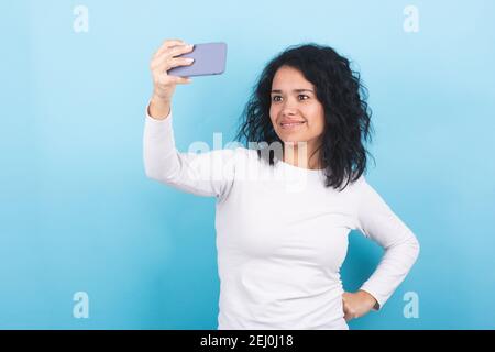 Brunette Mädchen nimmt ein Selfie mit ihrem Handy Stockfoto