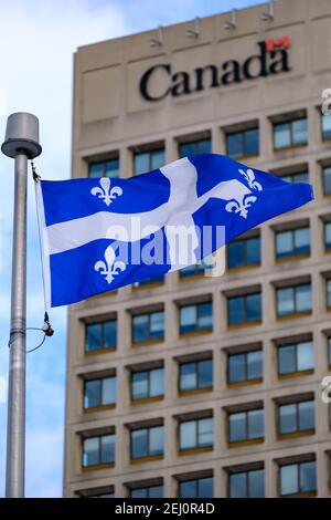 Ottawa, Ontario, Kanada - 6. Februar 2021: Die Provinzflagge von Quebec fliegt vor einem Gebäude der kanadischen Bundesregierung in Ottawa. Stockfoto