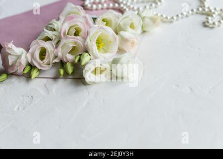 Luxus romantischen Hintergrund: Weiße Blumen, Perlen Halskette, Parfüm, Grußkarte auf weiß.Accessoires und Blumen. Online-Shopping oder Dating-Konzept Stockfoto