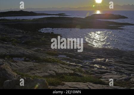 Norwegen, Norwegen; Meeresfelsen im Schein der untergehenden Sonne - die raue Landschaft Nordnorwegens. Seefelsen im Schein der unterliegenden Sonne Stockfoto