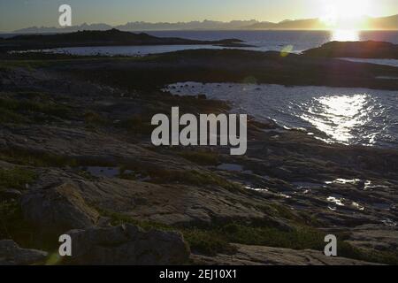 Norwegen, Norwegen; Meeresfelsen im Schein der untergehenden Sonne - die raue Landschaft Nordnorwegens. Seefelsen im Schein der unterliegenden Sonne Stockfoto