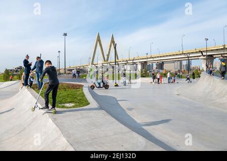 Kasan, Russland-26. September 2020: Walking Bewohner im Stadtpark auf dem Damm, Gruppen von Kindern und Jugendlichen in Schutzhelme auf Scoo Stockfoto