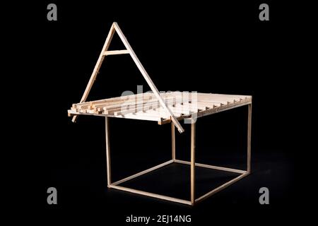 Holzrahmen eines Blockhauses. Ein Miniaturmodell eines Einfamilienhauses. Dunkler Hintergrund. Stockfoto