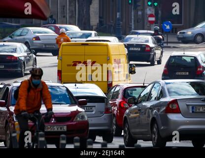 Bukarest, Rumänien - 05. Februar 2021 ein gelber DHL-Lieferwagen wird in der Hauptverkehrszeit auf einer Straße in Bukarest im starken Verkehr gesehen. Dieses Bild ist für ed Stockfoto