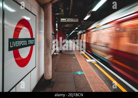 London UK Januar 2021 Zeichen der U-Bahn-Station Liverpool Street, Zug in Bewegung verschwommen. Plattformen während der nationalen Kovid der Vereinigten Staaten leer Stockfoto