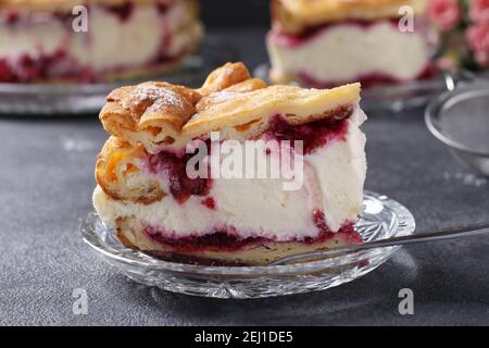 Stück Kuchen Karpatka mit Kirschen Nahaufnahme, traditionelle polnische Sahne Kuchen auf dunkelgrauem Hintergrund. Stockfoto