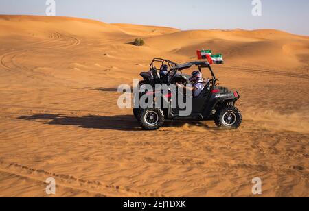 Zwei Quad-Bikes. Buggy-Autos fahren in Al Awir (Aweer) Wüstensafari Sanddünen-Tour mit emirates-Flaggen auf dem Dach, Extremsportfahrzeuge Stockfoto