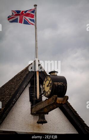 Union Jack auf einem Dach neben einer Uhr Stockfoto