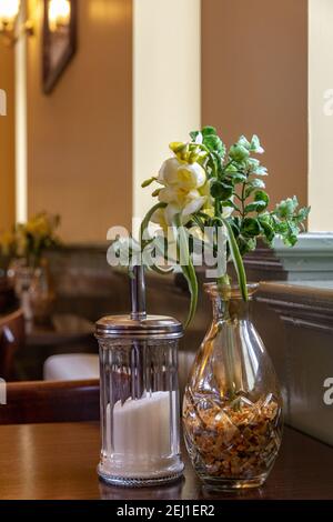 Gelbe Blumen auf einer Vase in einem Café Stockfoto