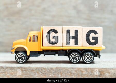 Spielzeug LKW halten Alphabet Buchstaben Block im Wort GHG (Treibhausgas) auf Holzhintergrund Stockfoto