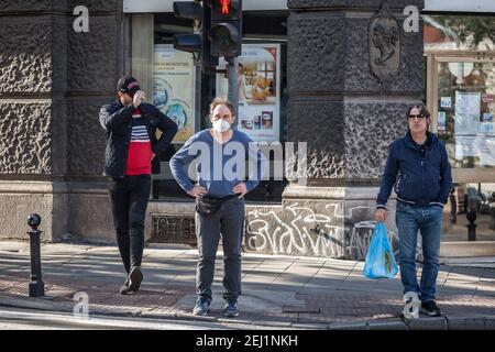BELGRAD, SERBIEN - 10. OKTOBER 2020: Drei Männer, mittleren Alters Blick auf einen Straßenverkehr auf einem Boulevard von Belgrad, nur einer trägt Gesichtsmaske zu schützen Stockfoto