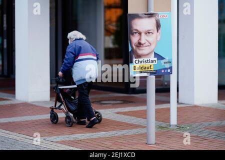 04. Februar 2021, Rheinland-Pfalz, Haßloch: Ein Mann mit Geher passiert ein Wahlplakat mit dem Porträt von Christian Baldauf, dem Spitzenkandidaten der CDU Rheinland-Pfalz für die anstehenden Landtagswahlen. (Zu dpa: 'Was macht Haßloch ticken? - Vorwahlstimmung in Mini-Deutschland in der Pfalz') Foto: Uwe Anspach/dpa Stockfoto