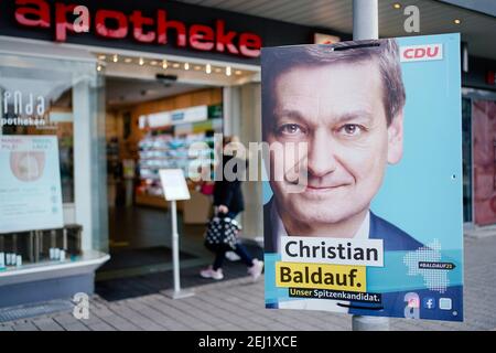 04. Februar 2021, Rheinland-Pfalz, Haßloch: Eine Frau geht hinter einem Wahlplakat in die Apotheke, ähnlich Christian Baldauf, dem Spitzenkandidaten der CDU Rheinland-Pfalz für die anstehenden Landtagswahlen. (Zu dpa: 'Was macht Haßloch ticken? - Vorwahlstimmung in Mini-Deutschland in der Pfalz') Foto: Uwe Anspach/dpa Stockfoto