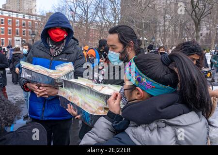 New York, Usa. Februar 2021, 20th. NEW YORK, NY - 20. FEBRUAR: Aktivist gibt veganes Essen zum Ende die Kundgebung der Gewalt gegen Asiaten im Washington Square Park am 20. Februar 2021 in New York City. Seit Beginn der Coronavirus-Pandemie hat die Gewalt gegenüber asiatischen Amerikanern deutlich höher zugenommen als in den Vorjahren. Das New York City Police Department (NYPD) berichtete 1.900 über einen Anstieg der anti-asiatischen Hassverbrechen um 2020%. Kredit: Ron Adar/Alamy Live Nachrichten Stockfoto