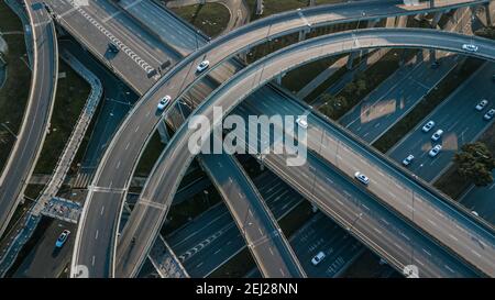 Top up Luftdrohne Blick auf erhöhte Straße und Verkehrsknotenpunkte in der chinesischen Metropole Chengdu an sonnigen Tagen. Moderne Straßenbauarbeiten Stockfoto