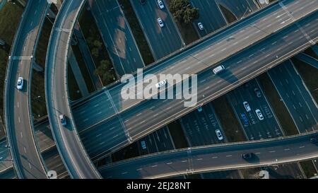 Top up Luftdrohne Blick auf erhöhte Straße und Verkehrsknotenpunkte in der chinesischen Metropole Chengdu an sonnigen Tagen. Moderne Straßenbauarbeiten Stockfoto