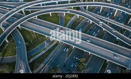 Top up Luftdrohne Blick auf erhöhte Straße und Verkehrsknotenpunkte in der chinesischen Metropole Chengdu an sonnigen Tagen. Moderne Straßenbauarbeiten Stockfoto