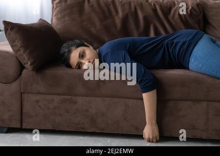 Müde indische Frau liegt auf dem Sofa Gefühl faul Stockfoto