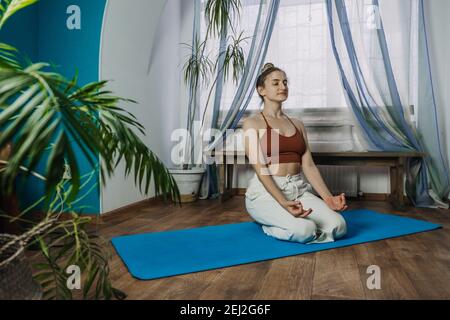 Selbstversorgung, Selbstmitleid, geistiges Wohlbefinden in der Welt nach der Pandemie. Psychische Gesundheit, Wohlbefinden, Meditation, um Angst zu beseitigen. Junge Frau, die darauf sitzt Stockfoto