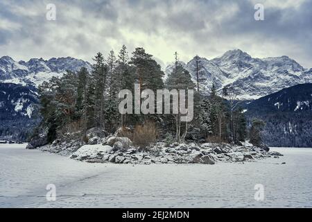 Insel im gefrorenen Eibsee mit Zugspitze am Wintertag Stockfoto