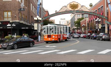 SAN DIEGO, CALIFORNIA USA - 30 JAN 2020: Gaslamp Quarter Historic Eingang Bogen Zeichen auf 5th Avenue. Orange kultige Retro-Trolley, Hop-on-Hop-off-Bus und Stockfoto