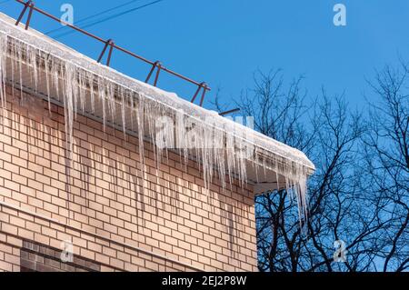 Dach Des Hauses Mit Schnee Und Eiszapfen Überhängend Stockfoto