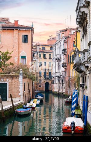 Atemberaubende Aussicht auf eine Gasse in Venedig mit Gebäuden mit Blick auf einen der Kanäle, die durch die Stadt laufen. Schöner Blick während des Sonnenaufgangs. Stockfoto