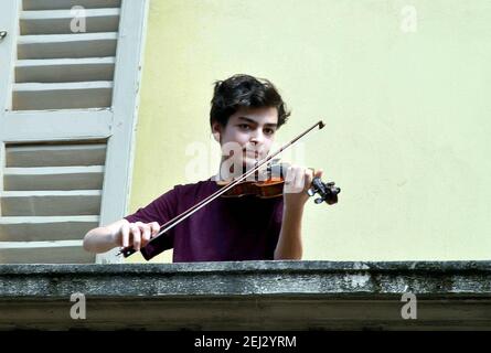 Reportage, Italien. März 2021, 13th. Mailand, Demonstrationen für April 25, mit Coronavirus Notfall, Junge am Fenster mit Geige singt Belle Ciao, in Corso San Gottardo (Mailand - 2020-04-25, Maurizio Maule) PS das Foto kann in Übereinstimmung mit dem Kontext verwendet werden, in dem es "aufgenommen wurde, Und ohne die diffamierende Absicht der Anstand der Menschen vertreten redaktionelle Verwendung nur Kredit: Unabhängige Fotoagentur/Alamy Live News Stockfoto