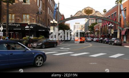 SAN DIEGO, CALIFORNIA USA - 30 JAN 2020: Gaslamp Quarter Historic Eingang Bogen Zeichen auf 5th Avenue. Orange kultige Retro-Trolley, Hop-on-Hop-off-Bus und Stockfoto