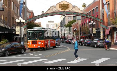 SAN DIEGO, CALIFORNIA USA - 30 JAN 2020: Gaslamp Quarter Historic Eingang Bogen Zeichen auf 5th Avenue. Orange kultige Retro-Trolley, Hop-on-Hop-off-Bus und Stockfoto