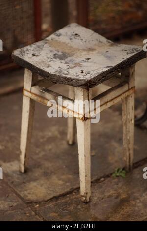 Alter fauler Hocker mit Estrichstützen im Hof. Stockfoto