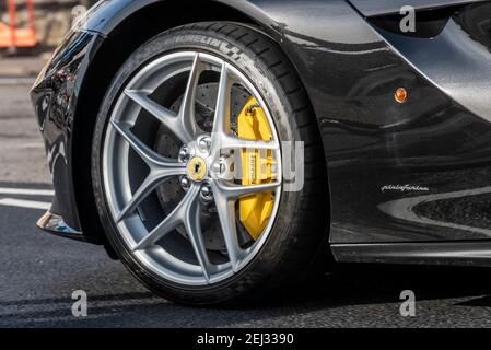 Ferrari Vorderrad und Bremssattel. Schwarzer Ferrari F12berlinetta Typ F152 mit Pininfarina-Logo. Brembo Carbon-Keramik-Einheit und gebohrte Scheibe Stockfoto