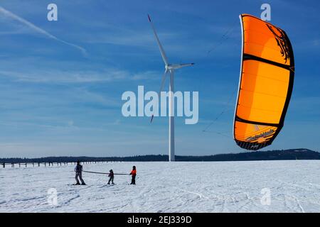 Schneekittenfamilie auf Schneebesen unter Windkraftanlage Tschechische Republik Krusne Hory Erzgebirge Erzgebirge Winter schneebedeckte Ebene Landschaft Stockfoto