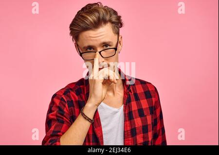 Ernster Mann in Brille, rosa Hintergrund, Emotion Stockfoto