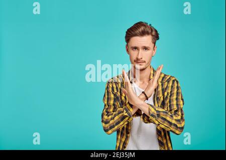 Ernster Mann mit gekreuzten Händen, blauer Hintergrund Stockfoto