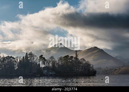 Episches Landschaftsbild mit Blick über Derwentwater im Lake District Catbells schneebedeckter Berg mit dichtem Nebel Rollen durch Tal Stockfoto