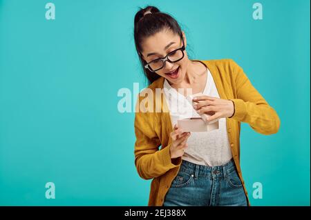 Glückliche Frau öffnet Geschenkbox, positive Emotion Stockfoto