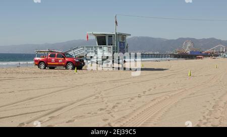 SANTA MONICA, LOS ANGELES CA USA - 28 Okt 2019: California summertime Beach aesthetic. Ikonischer blauer hölzerner Wachturm, roter Rettungsschwimmer Auto auf sandigen sonnigen Stockfoto