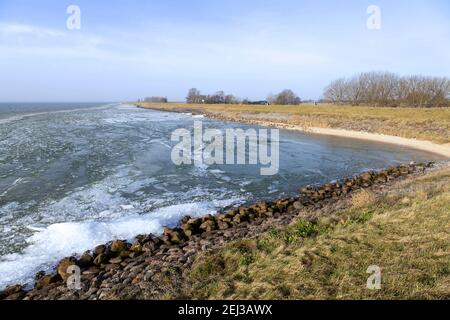 Gebogene Ansicht der Küste mit Eispickel auf dem IJsselmeer, vom Zuiderdijk-Damm bei Schellinkhout, Nordholland, Niederlande. Stockfoto
