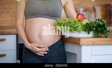 Schwangere Frau Bauch und Gemüse. Schwangerschaft, gesunde Ernährung und Menschen Konzept Stockfoto