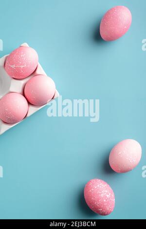 Rosa Ostereier auf türkisfarbenem Hintergrund. Stilvolle Ostern flach Lay Zusammensetzung, Blick von oben. Stockfoto