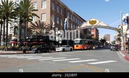 SAN DIEGO, CALIFORNIA USA - 13 FEB 2020: Gaslamp Quarter historisches Eingangsbogenschild auf 5th Avenue. Orange kultige Retro-Trolley, Hop-on-Hop-off-Bus und Stockfoto