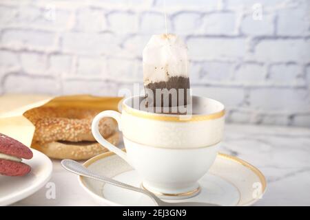 Grüner Tee mit Teebeutel auf Fliesen Hintergrund Stockfoto