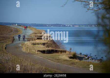 21. Februar 2021, Schleswig-Holstein, Lübeck: Tagesausflügler machen bei frühlingshaften Temperaturen einen Spaziergang entlang der Küste am Brodtener Steilufer in der Lübecker Bucht. Foto: Gregor Fischer/dpa Stockfoto